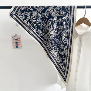 Vue détaillée d'un foulard en soie triangle bleu vintage stylisé avec une chemise blanche