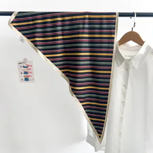 Vue détaillée d'un foulard en soie triangulaire à rayures multicolores sur un support
