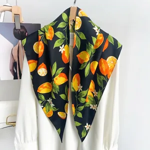 Primer plano detallado de un pañuelo de seda negro con estampado de limones y hojas verdes