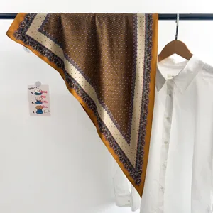 Détail macro d'un foulard en soie marron vintage suspendu sur un portant moderne