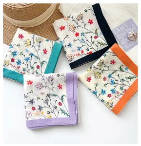 Flat lay detail view of four colorful floral cotton scarves with different borders