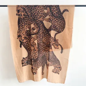 Detail view of a high-quality leopard print scarf featuring artistic overlapping jaguars