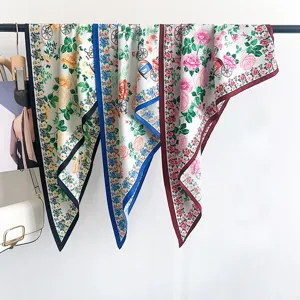 Varietà di eleganti foulard triangolari in seta con stampa floreale su un espositore