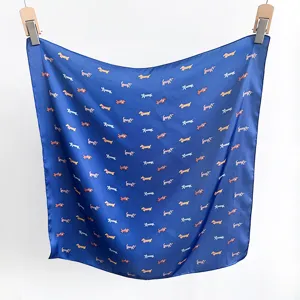 Quadratisches blaues Seidentuch mit Dackel-Motiv an Holzkleiderbügeln hängend