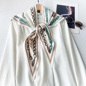 Elegant white triangle scarf with vintage chain print, styled on a chic white blouse