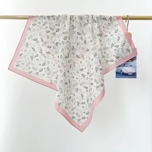Detailansicht eines quadratischen Baumwolltuches mit Blumenmuster und rosa Rand.