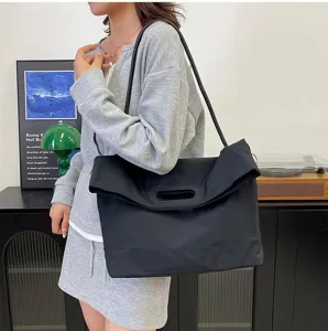 Woman carrying a large black nylon messenger bag for daily commute and sports.