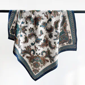 Dettaglio del motivo paisley vintage su sciarpa di seta bianca con bordo blu