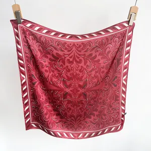 Close-up detail of a luxurious red faux silk square scarf with symmetrical floral patterns.