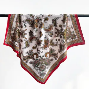 Elegante foulard di seta quadrato con motivo paisley drappeggiato su una barra nera.