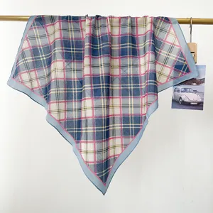 Detailansicht eines quadratischen Vintage-Baumwollschals mit Karomuster an einer Stange.