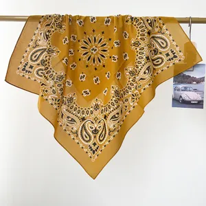 Vista detallada de un pañuelo bandana de algodón amarillo con estampado paisley de estilo retro.