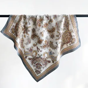 Dettaglio di un foulard quadrato in seta jacquard paisley vintage appeso con stile.