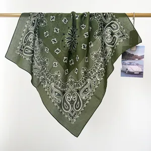 Vista detallada de la bandana de algodón con estampado paisley verde oliva en una vara