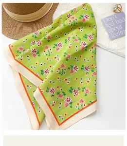 Dettaglio di un foulard quadrato in cotone a fiori verdi con bordo arancione e morbido