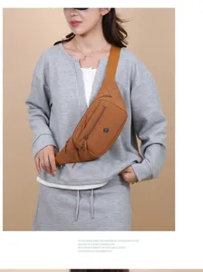 Casual lightweight brown nylon chest bag worn by Asian model over grey sweatshirt.