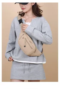 Detail shot of a lightweight beige nylon chest bag worn by a female model.