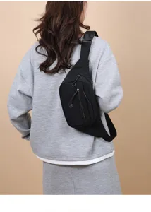 Detailed back view of a minimalist black sports chest bag worn by a female model.