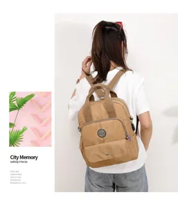 Detailansicht eines khakifarbenen Multifunktionsrucksacks mit USB-Ladeanschluss an einem Model
