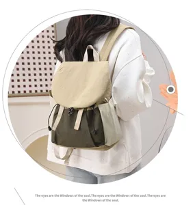 Detailed view of the khaki and olive green color-blocking travel backpack on a model