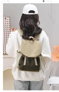 Back view of a woman wearing a khaki and olive green lightweight travel backpack