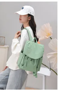 Detail view of an Asian model showcasing a mint green lightweight travel backpack