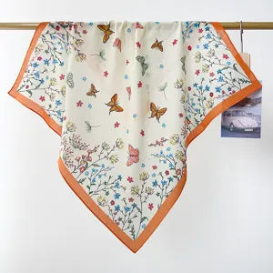 Close-up detail of a pastoral cotton square scarf with colorful butterfly and floral prints