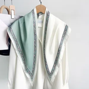 Vue détaillée du foulard triangulaire bicolore vert menthe avec bordure à motifs