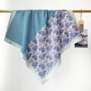 Detail van een blauwe katoenen vierkante sjaal met paisley- en houndstooth-motieven