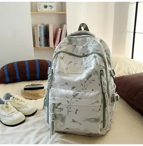 Detailed view of white backpack with landscape print in a cozy bedroom setting