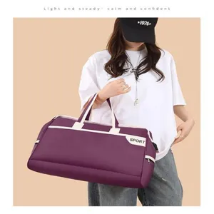 Model carrying a large purple travel duffel bag with SPORT print for gym and trips