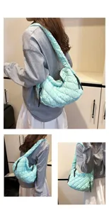 Close-up detail of the mint green quilted cloud bag, showing soft pleats and convenient strap.
