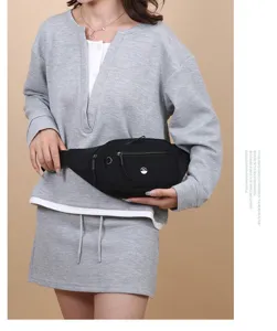 Close-up view of a minimalist black sport waist bag styled with a casual grey sweatshirt