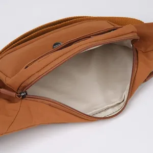 Fashionable tan nylon waist bag featuring adjustable strap and front zipper pocket