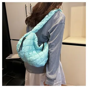 Detail view of light blue quilted cloud bag, featuring soft pleats and wide strap.