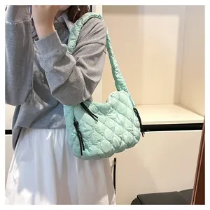 Detailed shot of mint green quilted cloud shoulder bag with stylish pleats and straps.