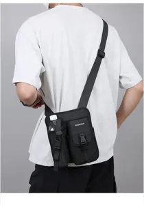Vue de dos d'un homme portant un sac bandoulière étanche noir avec porte-bouteille d'eau.