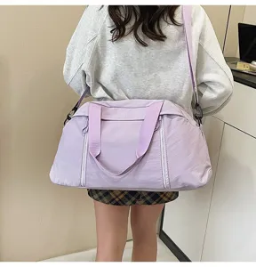 Rear view detail of a lavender purple gym and travel bag worn diagonally on the back