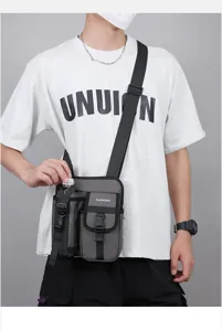 Vue détaillée du porte-bouteille sur un sac bandoulière gris pour hommes de plein air