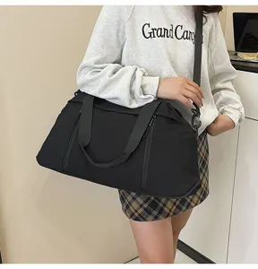 Model carrying a large black fitness travel bag over the shoulder for gym or travel use