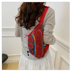 Back view of a trendy red corduroy sporty chest bag with colorful accents on model