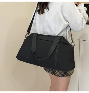 Detail view of a black sports yoga fitness bag worn by a model as a crossbody travel bag
