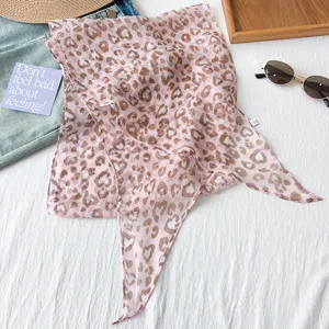 Detailansicht eines rosa herzförmigen Leoparden-Skinny-Schals mit Sommerrequisiten