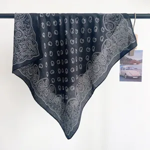 Primo piano di un foulard quadrato vintage nero con motivo paisley su un'asta nera