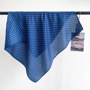 Detailed view of blue polka dot square neck scarf hanging on a display rod