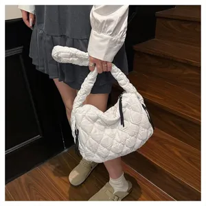 Detail shot of white pleated cloud bag, soft fabric and crossbody design on stairs.