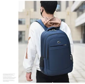 Back view of a man wearing a navy blue large capacity business laptop backpack in city.