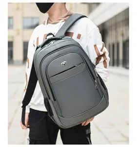 Close-up of grey large capacity business backpack worn by model in an outdoor setting