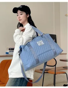 Bolsa de viaje acolchada azul claro de gran capacidad para deporte llevada por una modelo