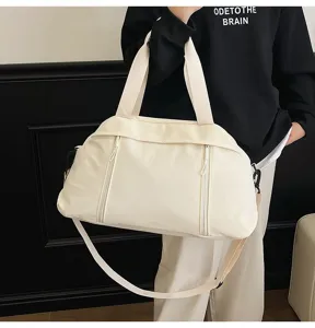 Close-up of white lightweight sports gym bag held by model with shoulder strap